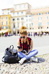 Italy, Verona, woman on town square looking at cell phone - GIOF001055