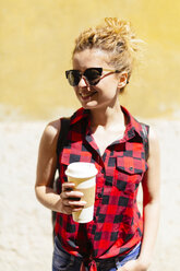Smiling young woman with coffee to go - GIOF001060