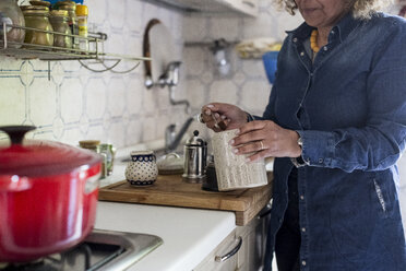 Frau bereitet Kaffee in der Küche zu - MAUF000622