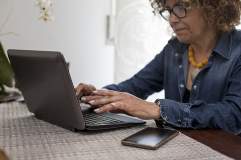 Woman using laptop at home stock photo