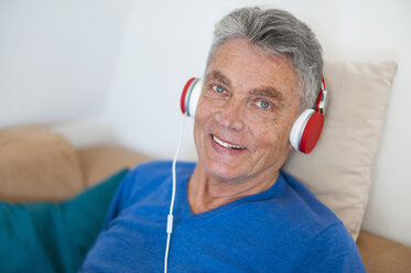 Portrait of smiling senior man wearing headphones - DIGF000491