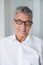 Porträt eines lächelnden älteren Mannes mit Brille und weißem Hemd - DIGF000523