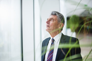 Senior businessman looking up at a window - DIGF000532