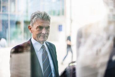 Senior man in suit looking at shop window - DIGF000537