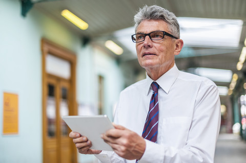 Senior businessman holding digital tablet stock photo