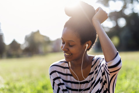 Lächelnde Frau, die mit Kopfhörern Musik hört, lizenzfreies Stockfoto