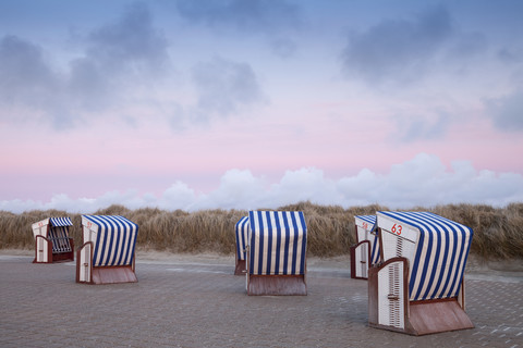 Germany, Lower Saxony, East Frisia, Nordstrand, beach with roofed wicker beach chairs, afterglow stock photo