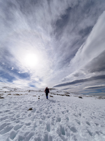 Spanien, Sierra de Gredos, Mann wandert im Schnee, lizenzfreies Stockfoto