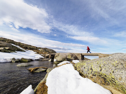 Spain, Sierra de Gredos, hiker crossing brook in mountains - LAF001634