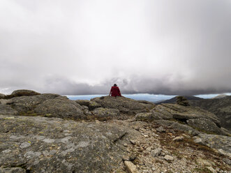 Spanien, Sierra de Gredos, Wanderer sitzt auf einem Felsen - LAF001637