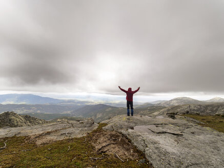 Spanien, Sierra de Gredos, Wanderer steht mit erhobenen Armen in den Bergen - LAF001638