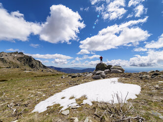 Spanien, Sierra de Gredos, Wanderer steht auf einem Felsen in einer Berglandschaft - LAF001643