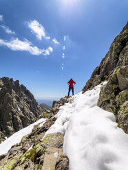 Spain, Sierra de Gredos, hiker standing on rock in mountainscape - LAF001649