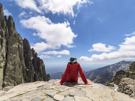 Spain, Sierra de Gredos, hiker sitting on rock in mountainscape - LAF001652
