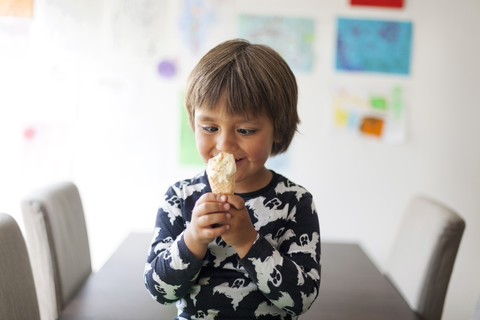 Porträt eines schielenden kleinen Jungen mit Eiswaffel, lizenzfreies Stockfoto