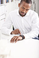 Businessman adjusting his smartwatch - MFRF000622