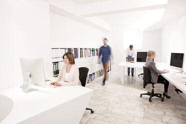 Vier Personen bei der Arbeit in einem modernen Büro - MFRF000642