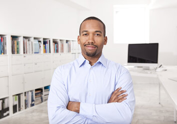 Portrait of businessman with arms crossed in the office - MFRF000705