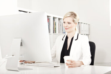 Businesswoman working at desk in the office - MFRF000711