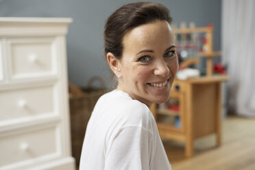 Brünette Frau lächelnd im Kinderzimmer - LFOF000231