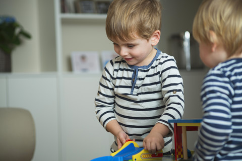 Zwei kleine Jungen spielen zu Hause mit Spielzeug, lizenzfreies Stockfoto