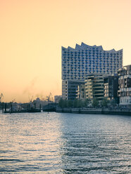 Germany, Hamburg, Elbphilharmonie at sunset with multi-family houses in the foreground - KRPF001748