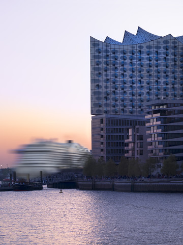Deutschland, Hamburg, Elbphilharmonie und fahrende Kreuzfahrtschiffe bei Sonnenuntergang, lizenzfreies Stockfoto