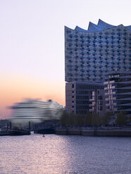 Germany, Hamburg, Elbphilharmonie and driving cruise liner at sunset - KRPF001751