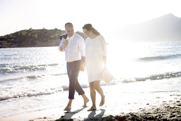 Spanien, Mallorca, schwangere Frau und Mann gehen am Strand spazieren - GDF000996