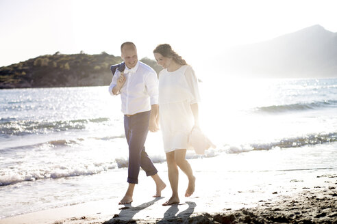 Spain, Majorca, pregnant woman and man walking on beach - GDF000996