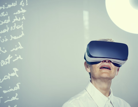 Senior woman wearing Virtual Reality Glasses stock photo