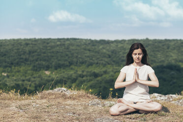 Young woman meditating on the cliff - BZF000291