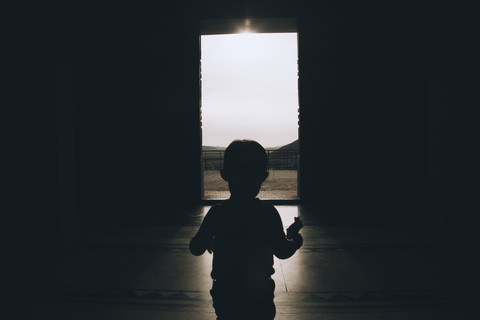 Bosnien und Herzegowina, Trebinje, Silhouette eines kleinen Jungen, der zum Ausgang eines Hauses geht, lizenzfreies Stockfoto