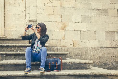 Kroatien, Dubrovnik, Tourist sitzt auf den Stufen der Mariä-Entschlafenskirche und fotografiert - ZEDF000153