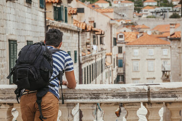 Kroatien, Dubrovnik, Rückenansicht eines Touristen mit Rucksack, der auf die Stadt blickt - ZEDF000154