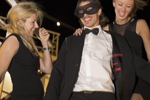 Zwei Frauen und ein Mann lachen und tanzen auf einem Kreuzfahrtschiff bei Nacht - ONBF000020