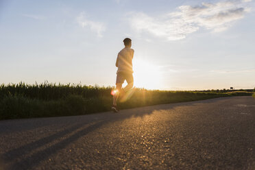 Deutschland, junger Mann beim Joggen, gegen die Sonne - UUF007373