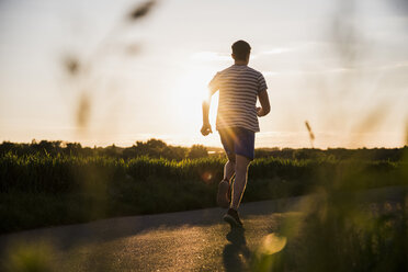 Deutschland, junger Mann beim Joggen, gegen die Sonne - UUF007377