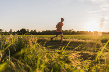 Deutschland, junger Mann beim Joggen, gegen die Sonne - UUF007391