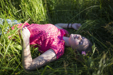 Dreaming teenage girl lying on a meadow - MRAF000054