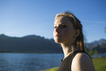 Italy, Lecco, portrait of teenage girl sitting at lakeshore - MRAF000057