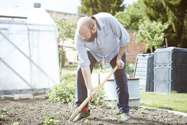 Junger Mann arbeitet im Garten und gräbt - SEGF000547
