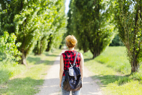 Rückenansicht einer Frau mit Rucksack in der Natur - GIOF001130