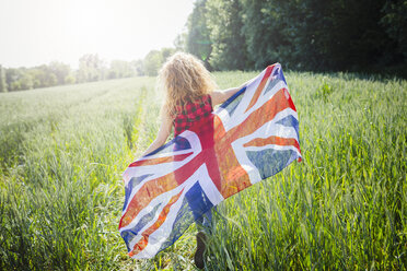 Rückenansicht einer Frau mit Union Jack in der Natur - GIOF001137