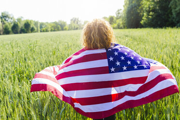 Rückenansicht einer Frau mit amerikanischer Flagge in der Natur - GIOF001138