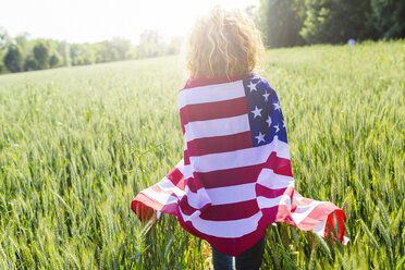 Rückenansicht einer Frau mit amerikanischer Flagge in der Natur - GIOF001139