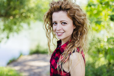 Portrait of smiling woman with curly hair - GIOF001144