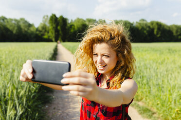 Frau macht Selfie mit Smartphone in der Natur - GIOF001147