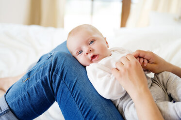 Baby auf dem Schoß der Mutter liegend - HAPF000462