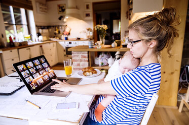 Mother with baby at home working with laptop - HAPF000473